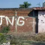 View of a bullet-riddled wall bearing the initials of the criminal group Cartel Jalisco Nueva Generacion (CJNG) at the entrance of the community of Aguililla, state of Michoacan, Mexico, on April 23, 2021. The municipality of Aguililla is being threatened due to the confrontation of organized crime groups called the Jalisco Nueva Generacion Cartel (CJNG) and the Michoacan Family (now called Viagras). (Photo by ENRIQUE CASTRO / AFP)