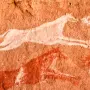 Una cazador con dos perros, representados en las cuevas rupestres de Tadrart Acacus (Libia).