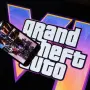 This illustration photo created in Los Angeles, December 4, 2023, shows Rockstar Games Grand Theft Auto VI trailer played on a screen in front of the game title. The first trailer for "Grand Theft Auto VI" was officially released ahead of schedule December 4, 2023 due to a leak, touting a 2025 release for the next chapter of the massively successful video game franchise. (Photo by Chris DELMAS / AFP)