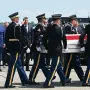 US President Donald Trump and Secretary of Defense Pete Hegseth salute as a US Army carry team carries the flag-draped transfer case containing the remains of Sgt. Michael Emmanuel Swinton, 30, of Fayetteville, North Carolina, during a dignified transfer solemn event for US service members killed during operations in the Middle East, at Dover Air Force Base in Dover, Delaware, on July 22, 2026. Swinton was killed in action on July 19 at at Erbil Air Base in Iraq. (Photo by SAUL LOEB / AFP)